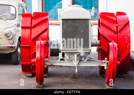 Front view of old white tractor with red wheels Stock Photo