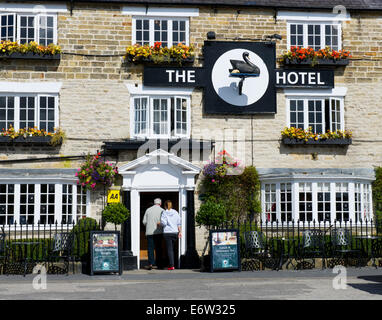 Man and woman walking into the Black Swan Hotel, Helmsley, North Yorkshire, England UK Stock Photo