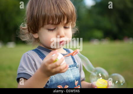 Little boy blowing soap bubbles in park. Stock Photo