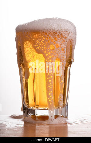 Glass of brimming beer. Stock Photo