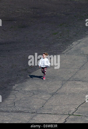 (140901) -- FRANKFURT (GERMANY), Sept. 1, 2014 (Xinhua) -- A girl runs in the site of former Sachsenhausen Nazi concentration camp in Oranienburg, near Berlin, Germany, on Aug. 21, 2014. The Sachsenhausen Nazi concentration camp was built in Oranienburg about 35 km north of Berlin in 1936 and imprisoned about 220,000 people between 1936 and 1945. The site now served as a memorial and museum to learn about the history within the authentic surroundings, including the remnants of buildings and other relics of the camp. (Xinhua/Luo Huanhuan) Stock Photo
