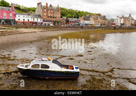 Beached boat on Oban Bay Beach and view towards George Street, Oban, Argyll & Bute, Scotland, UK  Model Release: No.  Property Release: No. Stock Photo