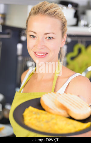 Young Mother Cooking at Home. Stock Photo