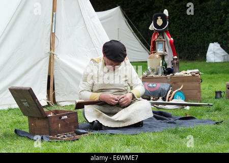 44th East Essex Regiment of foot solider repairing a rifle at a historical re-enactment. Detling, Kent, UK Stock Photo