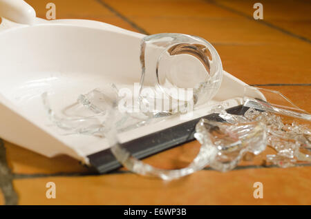 remnants pile of broken glass on floor after accident and glass slipped out of wet hands knocked over Stock Photo