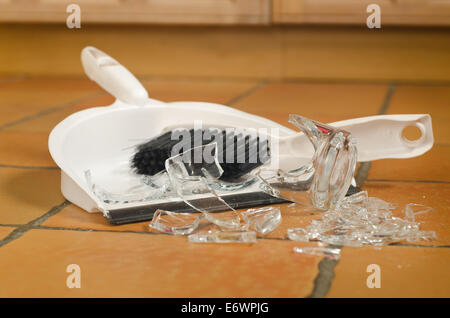 remnants pile of broken glass on floor after accident and glass slipped out of wet hands knocked over Stock Photo