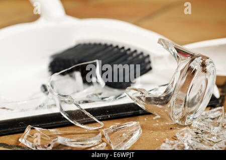 remnants pile of broken glass on floor after accident and glass slipped out of wet hands knocked over Stock Photo