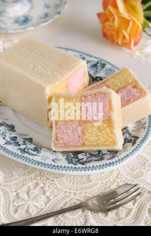 Battenberg Cake or Battenberg Square a sponge cake with pink a yellow checks covered in marzipan Stock Photo