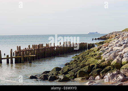 Wooden groynes & rock armour protecting the coastline from erosion at East Lane Bawdsey Suffolk UK Stock Photo