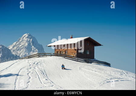 People sledging at Eckbauer, Alpspitze in the background, Garmisch-Partenkirchen, Bavaria, Germany Stock Photo