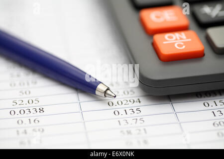 Financial statements. Calculator, ballpoint pen on financial statements. Focus on pen. SDOF. Closeup. Stock Photo