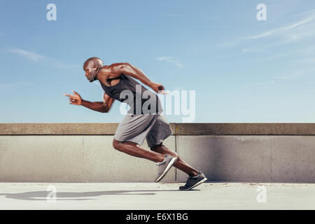 Man start running on the pathway with the blue sky in the background and copy space around him. Motion blur. Stock Photo