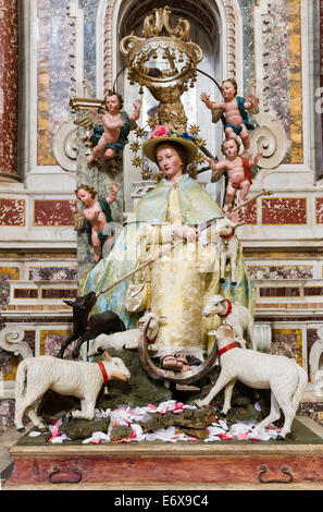 A female saint in brocade robes standing on a crescent moon, with putti and sheep, popular piety, cathedral Stock Photo