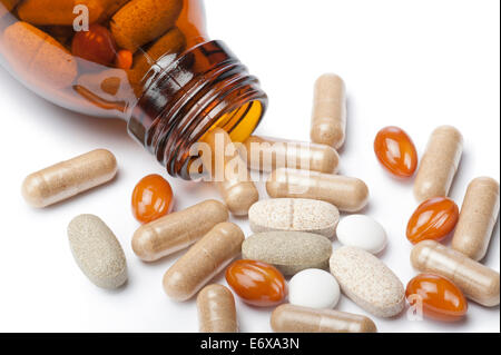 bottle with variety of pills and tablets, close up on white background Stock Photo