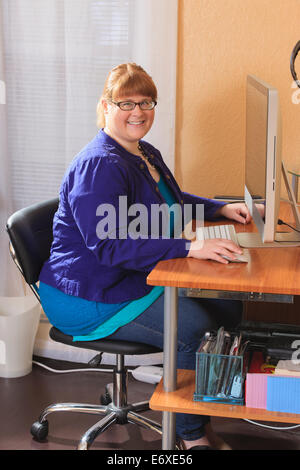 Woman is legally blind using large type on her computer screen Stock Photo