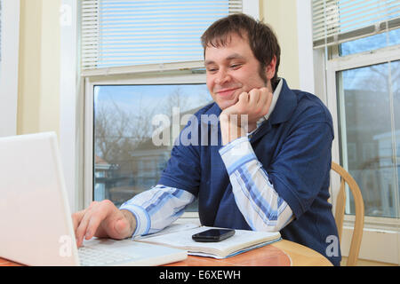 Technology engineer and programmer with Aspergers working on his computer from home Stock Photo