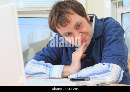 Technology engineer and programmer with Aspergers working on his computer from home Stock Photo