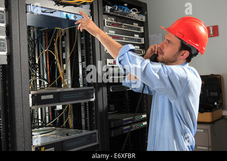 Network engineer on phone performing trouble shooting Stock Photo
