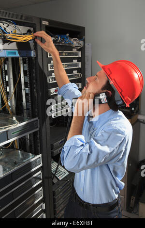 Network engineer on phone performing trouble shooting Stock Photo