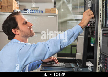 Network engineer working on computer in data center Stock Photo