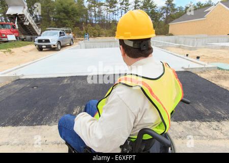 Construction supervisor with Spinal Cord Injury inspecting house foundation work Stock Photo