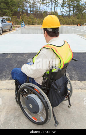 Construction supervisor with Spinal Cord Injury inspecting house foundation work Stock Photo