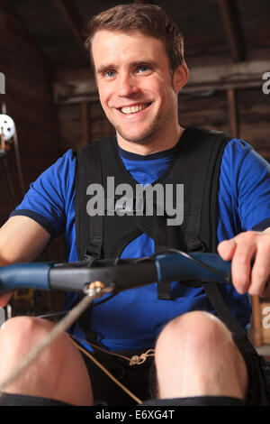 Man with spinal cord injury using his rowing machine Stock Photo