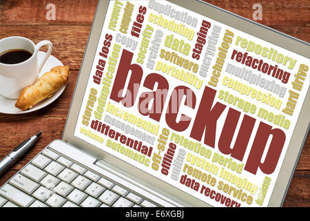 backup word cloud on a laptop screen with a cup of coffee and cookie Stock Photo