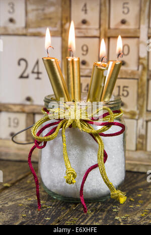 Four golden candles -  traditional christmas decoration with wood - with a calendar Stock Photo