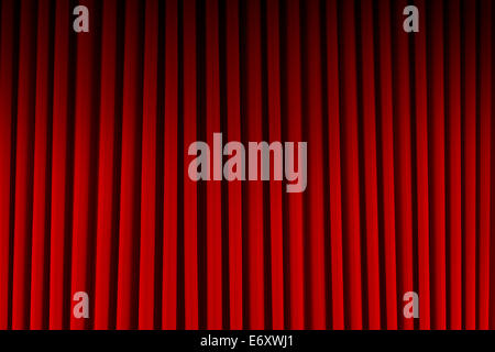 Red Velvet Stage Curtains Dim Lit Background. Stock Photo