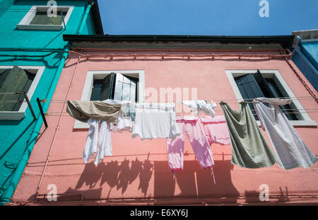 Clothes drying on a washing line outside a house on the island of Burano in the Venice lagoon, Italy Stock Photo