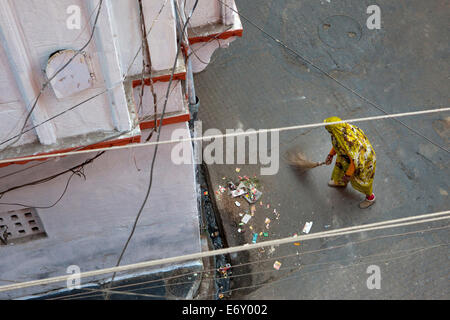 View from above to woman wearing a sari and sweeping the street, Udaipur, Rajasthan, India Stock Photo