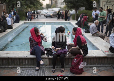 Tehran, Iran. 1st Sep, 2014. Iranian young women sit on a side of a pool in Tehran's Artists Park. Credit:  Morteza Nikoubazl/ZUMA Wire/Alamy Live News Stock Photo