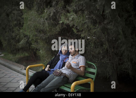 Tehran, Iran. 1st Sep, 2014. An Iranian couple talk to each other as they sit in Tehran's Artists Park. Credit:  Morteza Nikoubazl/ZUMA Wire/Alamy Live News Stock Photo