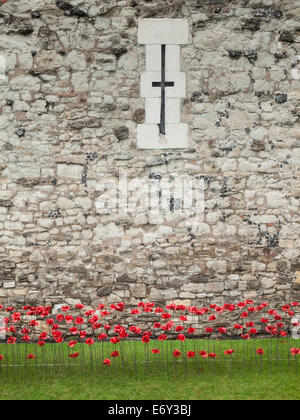 detail of the ceramic poppies exhibit  at the tower of london during heavy rain with the tower wall behind. Stock Photo