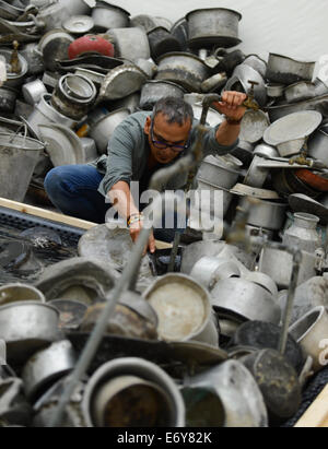 Frankfurt/Main, Germany. 1st Sept, 2014. Artist Subodh Gupta from New Delhi helps set up his installation 'This is not a fountain (2011)' at the Museum for Modern Art (MMK) in Frankfurt/Main, Germany, 01 September 2014. The exhibition 'Subodh Gupta - Everything is Inside' will run at MMK 1 from 12 September 2014 till 18 January 2015. Credit:  dpa picture alliance/Alamy Live News Stock Photo