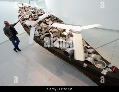 Frankfurt/Main, Germany. 1st Sept, 2014. Artist Subodh Gupta from New Delhi stands next to his installation 'All in the same boat (2012/13)' at the Museum for Modern Art (MMK) in Frankfurt/Main, Germany, 01 September 2014. The exhibition 'Subodh Gupta - Everything is Inside' will run at MMK 1 from 12 September 2014 till 18 January 2015. Credit:  dpa picture alliance/Alamy Live News Stock Photo