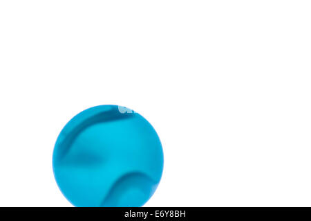 Close up of a blue glass marble with stripes on a white background Stock Photo