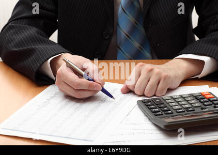 Businessman viewing financial statements. Shallow depth of field. Selective focus. Closeup. Stock Photo