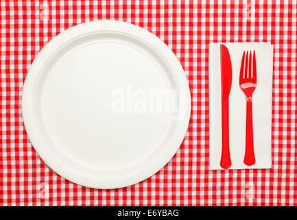 Paper Plate on Red Checkered Table Cloth wtih Plastic Utnesils and Napkin. Stock Photo