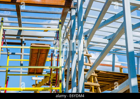 Scaffolds of bright colors against blue sky and white clouds Stock Photo