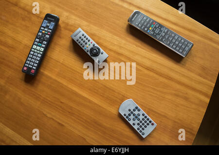 Four remote controls on a wooden table. FOR EDITORIAL USE ONLY. Stock Photo