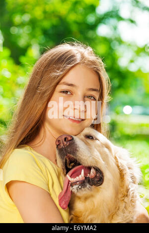 Happy teenage girl hugging dog outside portrait Stock Photo