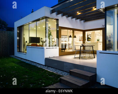 Dusk shot of Extension looking toward Living Room with Kitchen and Dining Room beyond. High Barnet House, London, UK. Stock Photo