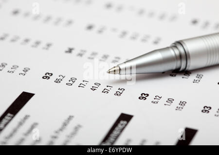 Analysis of financial statements. Focus on pen. Shallow depth of field. Closeup. Stock Photo