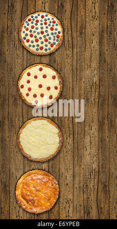 phased making of tart with raspberries, blueberries, vanilla custard and sugar powder, on old wooden table Stock Photo