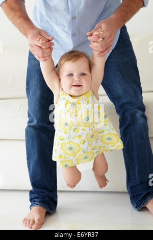 Father playing with baby daughter at home Stock Photo