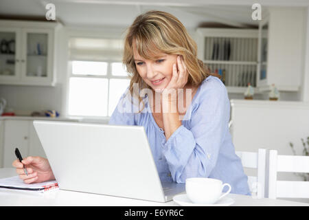 Mid age woman working at home on laptop Stock Photo