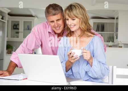 Mid age couple working at home on laptop Stock Photo