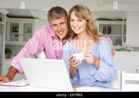 Mid age couple working at home on laptop Stock Photo